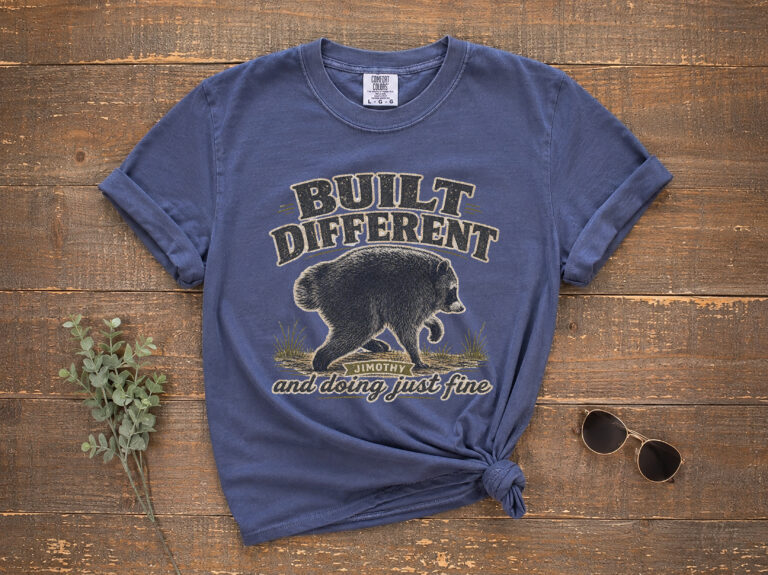 Featured image of a Jimothy raccoon shirt with vintage distressed artwork and BUILT DIFFERENT wording.