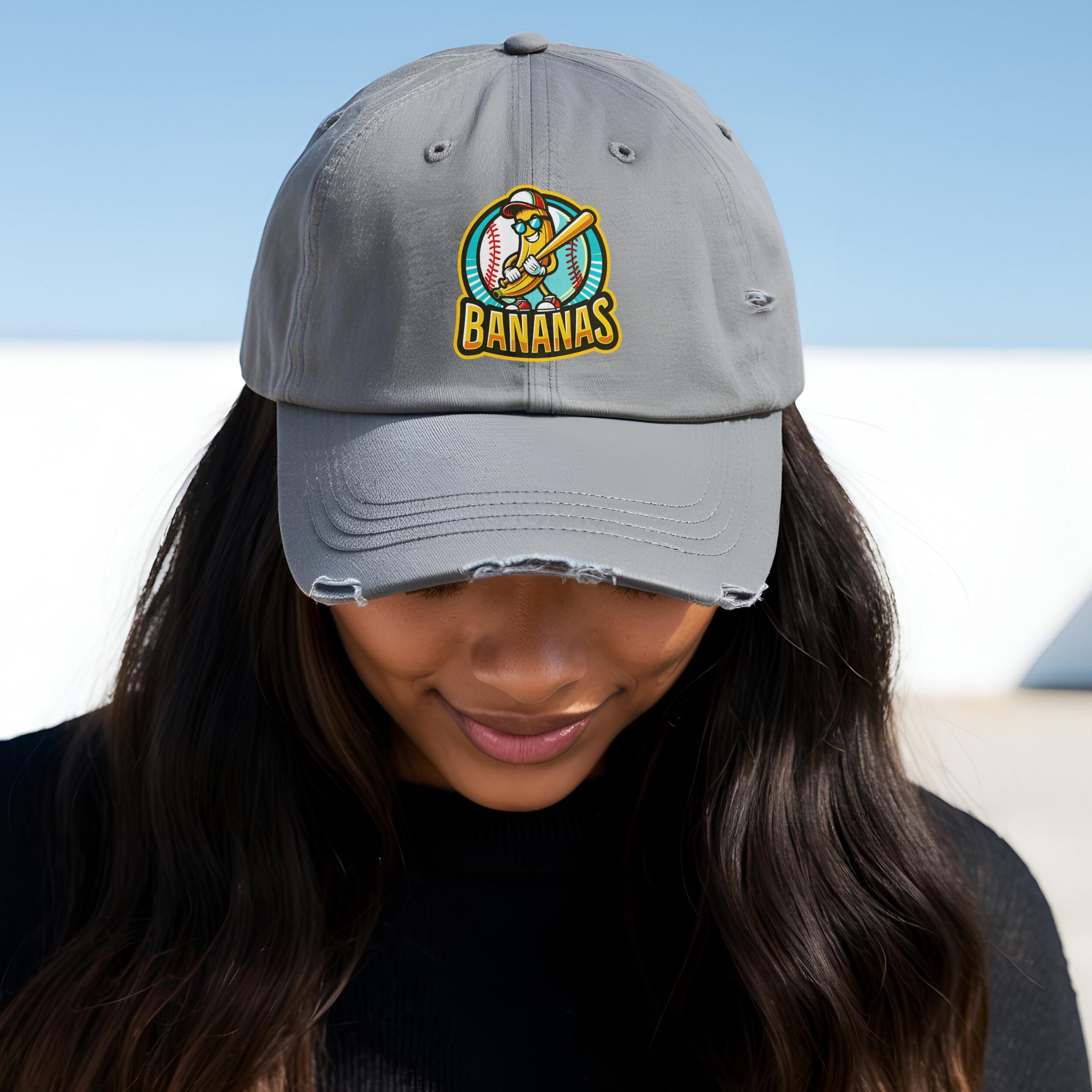 Black banana baseball cap with a cartoon banana holding a bat and baseballs on the front.